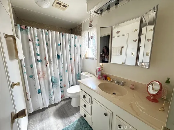 a bathroom with a sink a toilet and a mirror
