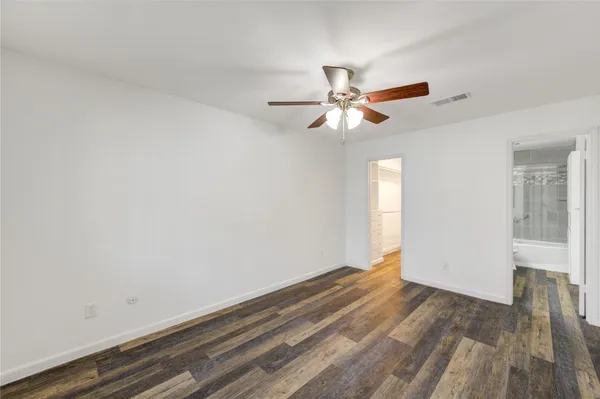 a view of a room with wooden floor and ceiling fan
