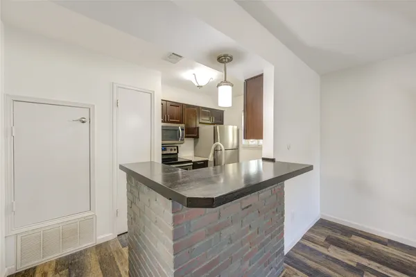 a kitchen with granite countertop a sink stove and refrigerator