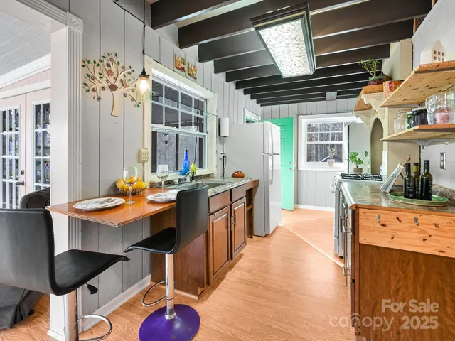 a kitchen with stainless steel appliances kitchen island granite countertop a table chairs and a refrigerator