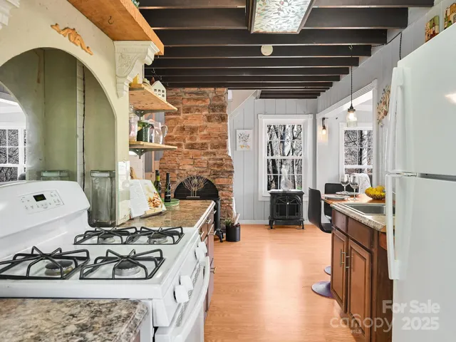 a kitchen with a stove a refrigerator and a fireplace