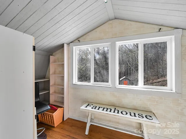 a view of a room with wooden floor and a window