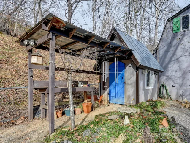 a view of a wooden house with a large tree and a yard