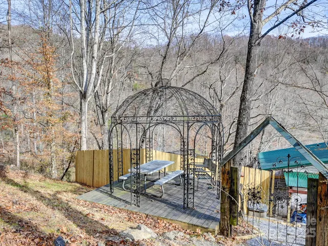 a view of wooden house with a yard and covered with snow