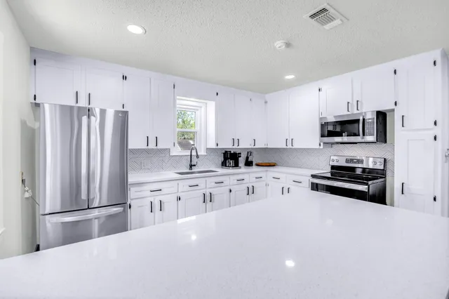 a kitchen with stainless steel appliances a refrigerator sink microwave and cabinets