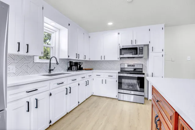 a kitchen with stainless steel appliances white cabinets and a sink