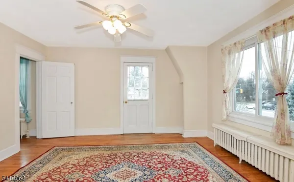 a view of a room with window wooden floor and front door
