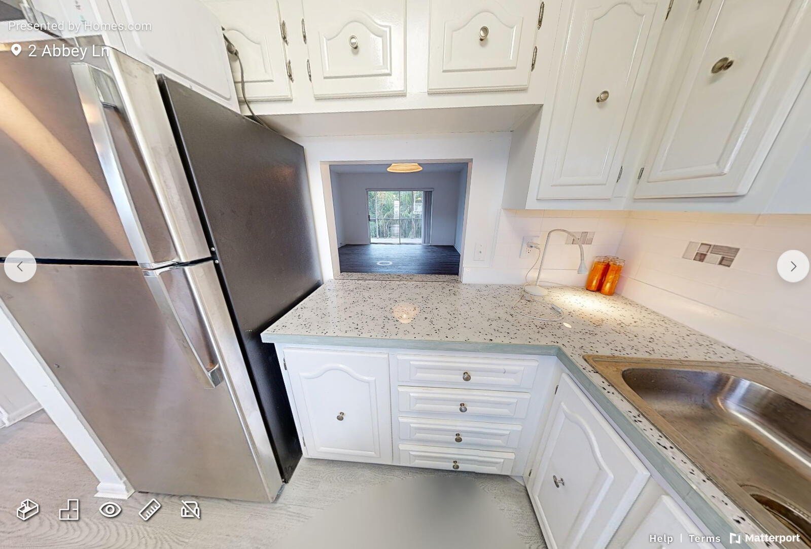 2 2 Abbey Lane, Unit 203 Delray Beach, FL 33446 - Photo 5 of 22 a kitchen with a sink a refrigerator and cabinets