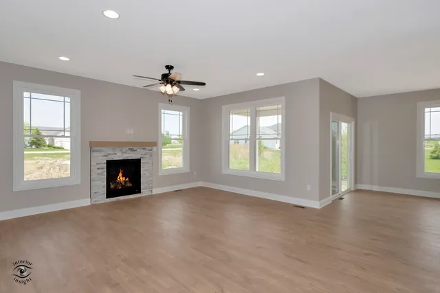 an empty room with windows and fireplace