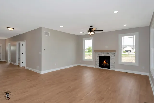 a view of an empty room with a fireplace and a window
