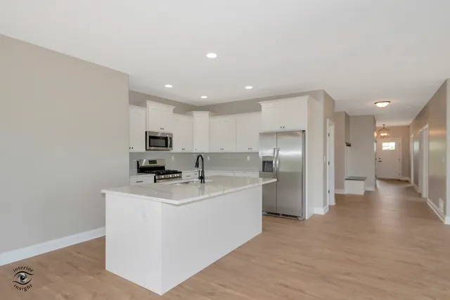 a kitchen with stainless steel appliances a refrigerator sink and microwave