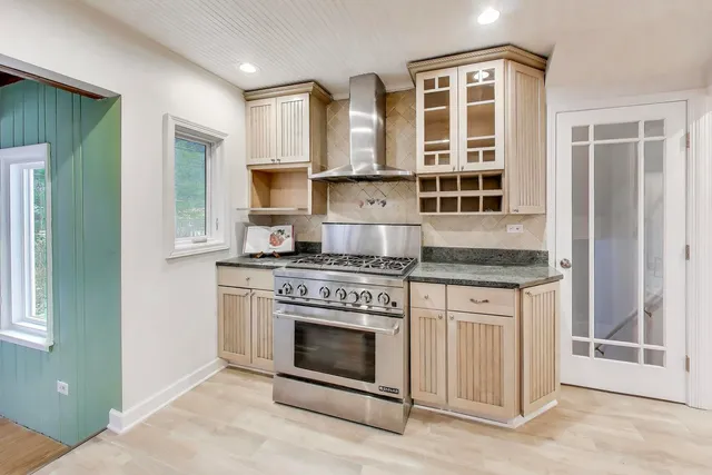 a kitchen with stainless steel appliances granite countertop a stove and cabinets
