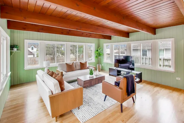a living room with furniture a flat screen tv and a large window
