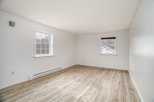 39 Berlin Street, Unit 315 Clinton, MA 01510 - Photo 12 of 22 an empty room with wooden floor and windows