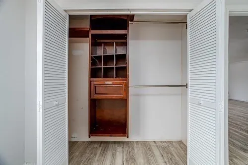 a view of a bedroom with wooden floor and a bathroom