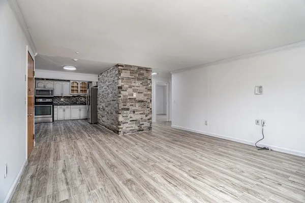 a view of empty room with wooden floor
