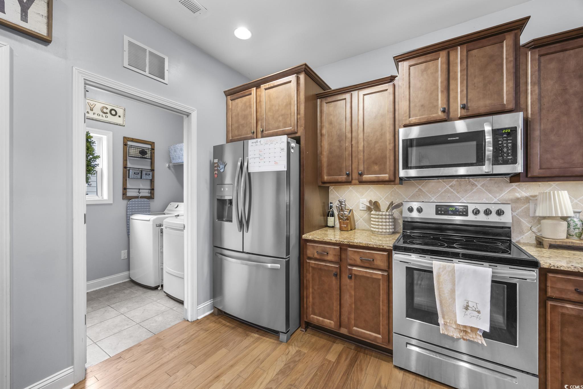 575 Shaftesbury Lane Conway, SC 29526 - Photo 18 of 39 Kitchen with appliances with stainless steel finishes, tasteful backsplash, light stone counters, washer and dryer, and recessed lighting