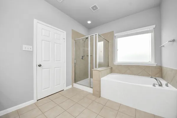 a spacious bathroom with a tub shower and window
