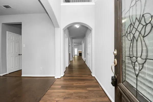 a view of a hallway with wooden floor and staircase