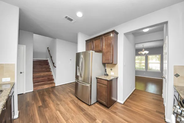 a kitchen with a refrigerator and a stove top oven
