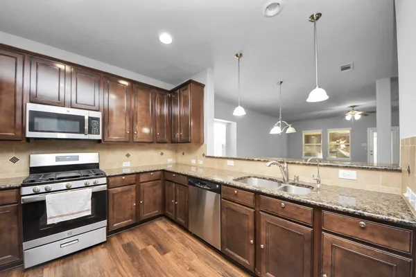 a kitchen with granite countertop stainless steel appliances and wooden cabinets