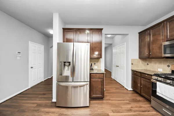 a kitchen with stainless steel appliances granite countertop a refrigerator and a stove