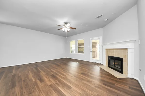 a view of an empty room with a fireplace and a window