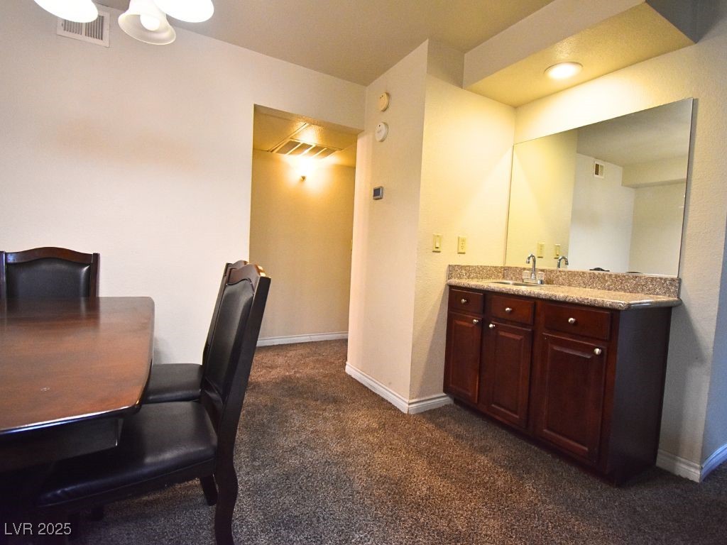 2451 North Rainbow Boulevard, Unit 1130 Las Vegas, NV 89108 - Photo 12 of 21 Dining area featuring dark carpet and baseboards