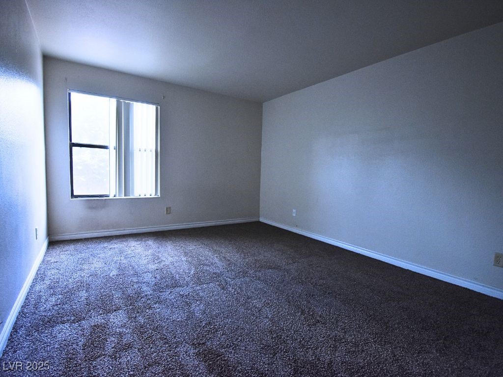 2451 North Rainbow Boulevard, Unit 1130 Las Vegas, NV 89108 - Photo 13 of 21 Spare room with dark carpet and baseboards