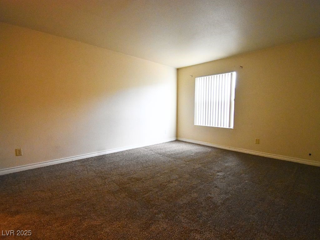 2451 North Rainbow Boulevard, Unit 1130 Las Vegas, NV 89108 - Photo 15 of 21 Unfurnished room featuring dark carpet and baseboards