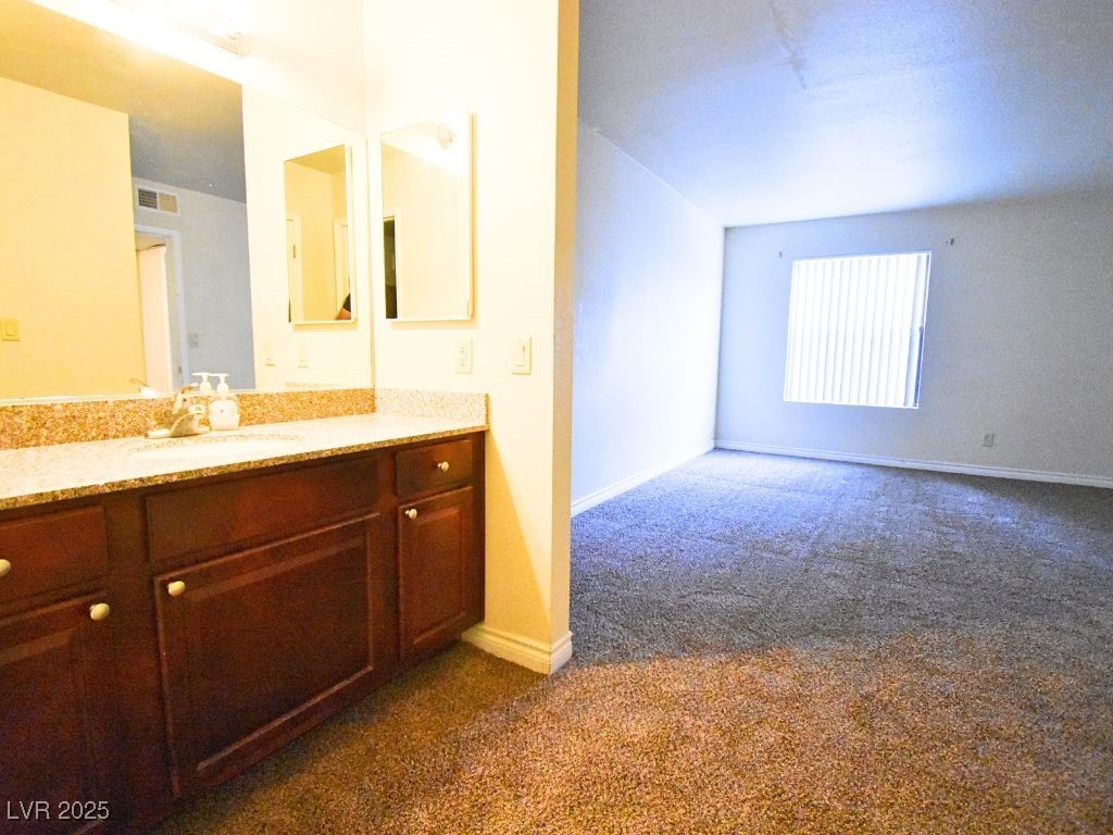 2451 North Rainbow Boulevard, Unit 1130 Las Vegas, NV 89108 - Photo 16 of 21 Bathroom featuring dark colored carpet and vanity