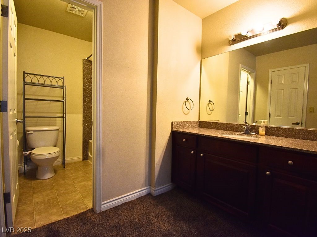 2451 North Rainbow Boulevard, Unit 1130 Las Vegas, NV 89108 - Photo 17 of 21 Full bathroom featuring vanity, curtained shower, dark tile patterned flooring, and dark colored carpet
