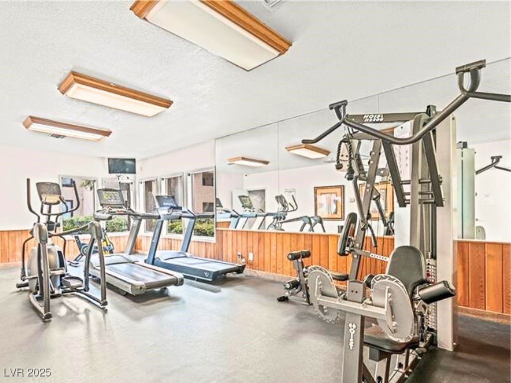 2451 North Rainbow Boulevard, Unit 1130 Las Vegas, NV 89108 - Photo 21 of 21 Gym with wood walls, wainscoting, and a textured ceiling