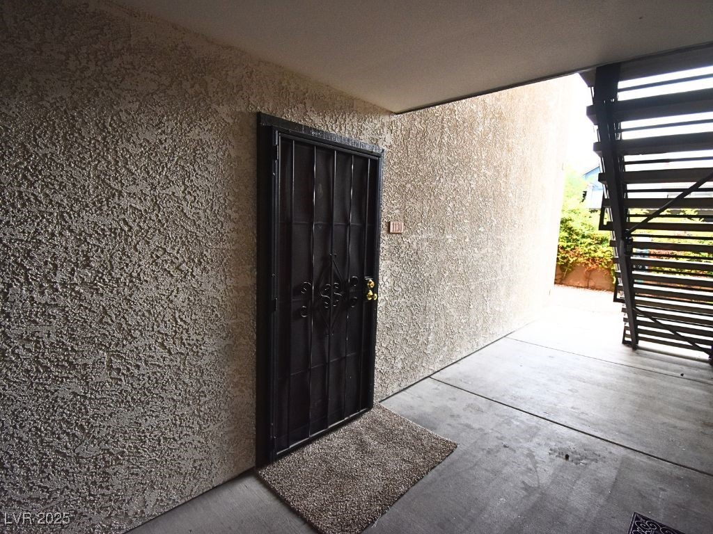 2451 North Rainbow Boulevard, Unit 1130 Las Vegas, NV 89108 - Photo 5 of 21 Property entrance featuring stucco siding and a patio area