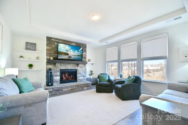 a living room with furniture a flat screen tv and a fireplace