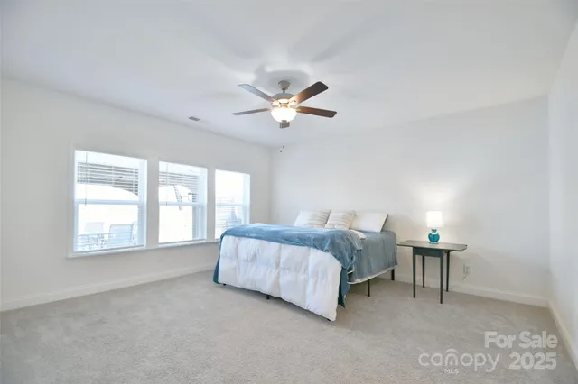 a bed room with a bed and a ceiling fan