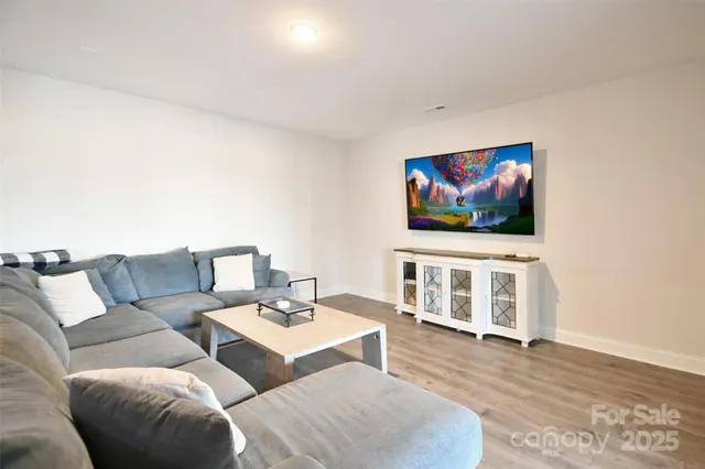 a living room with couches a coffee table and a flat screen tv