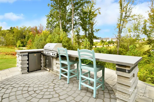 a view of a patio with table and chairs with wooden fence and plants
