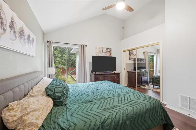 a bedroom with a large bed and a flat tv screen on dresser