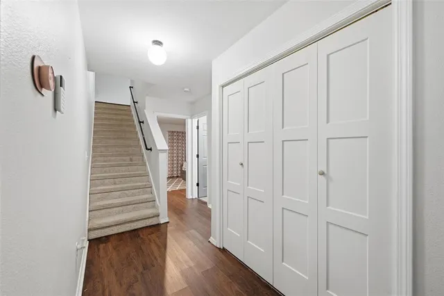 a view of a hallway with wooden floor and staircase