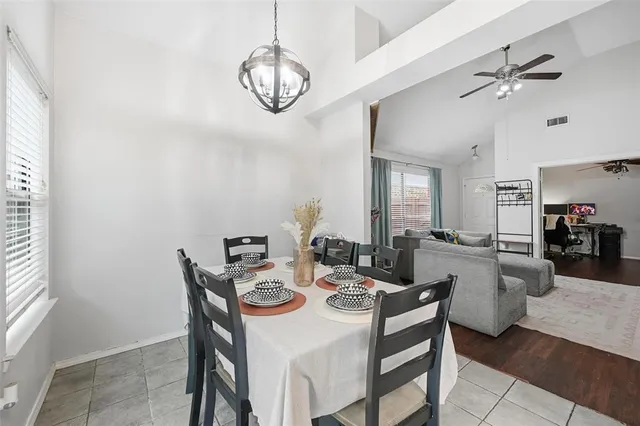 a view of a dining room with furniture and a chandelier fan