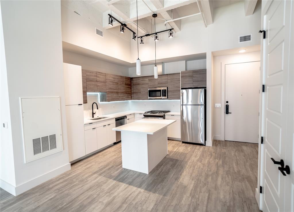 a kitchen with stainless steel appliances a white stove top oven and a chandelier