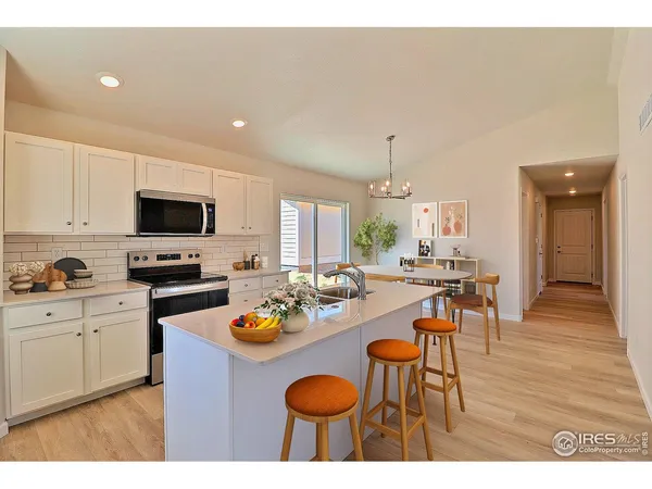 a kitchen with a dining table and chairs with wooden floor