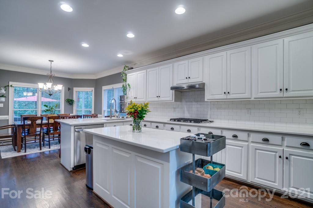 833 Amanda Drive Matthews, NC 28104 - Photo 20 of 48 a kitchen with kitchen island granite countertop a sink cabinets and wooden floor