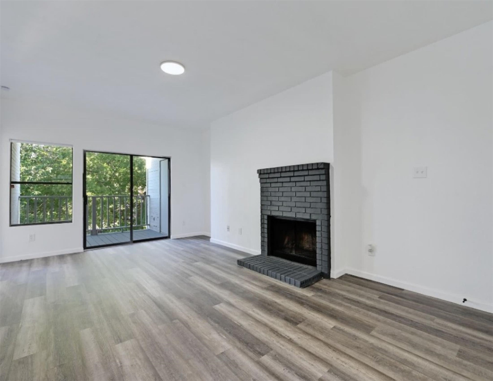9508 Kempler Drive, Unit B Austin, TX 78748 - Photo 2 of 12 an empty room with wooden floor fireplace and windows
