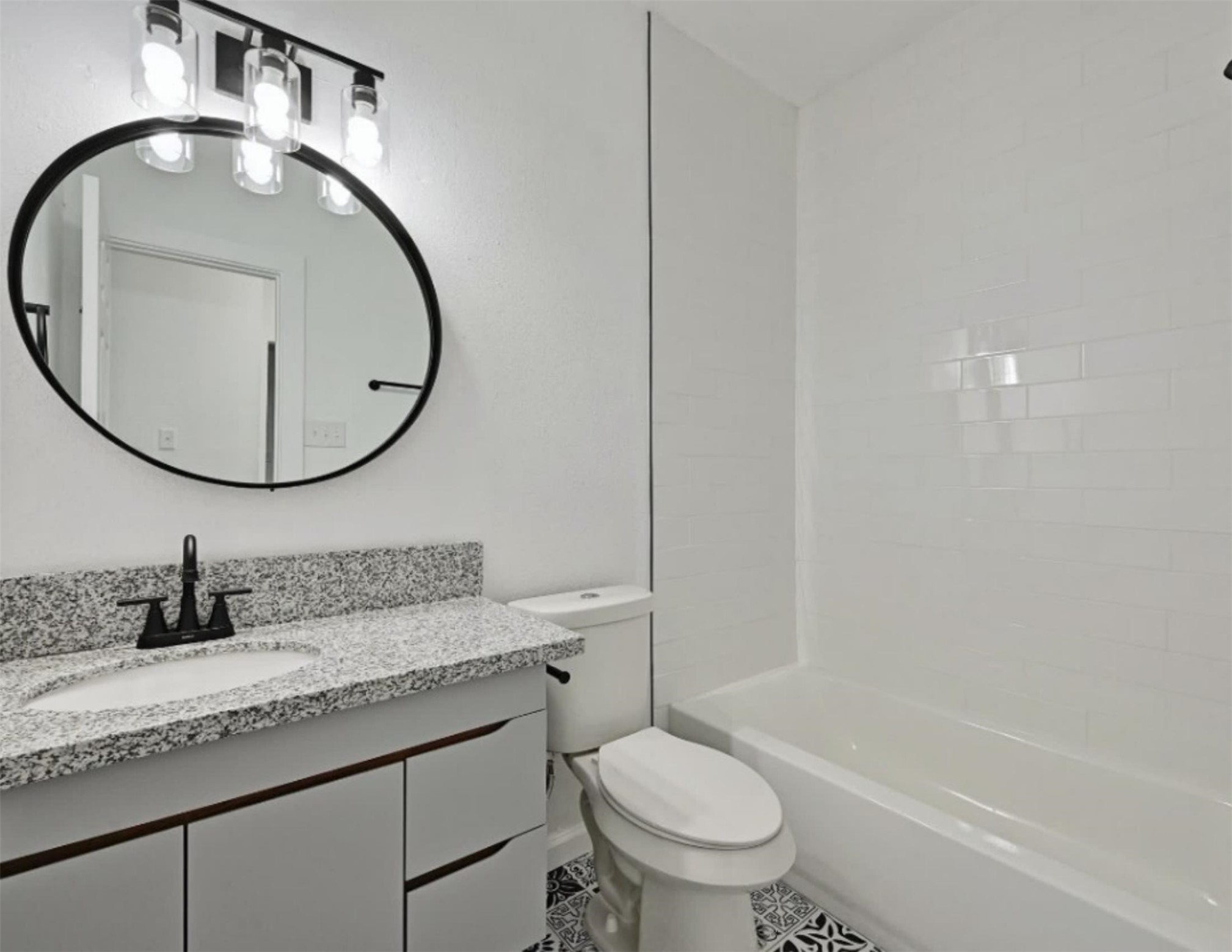 9508 Kempler Drive, Unit B Austin, TX 78748 - Photo 3 of 12 a bathroom with a granite countertop toilet a sink and a mirror