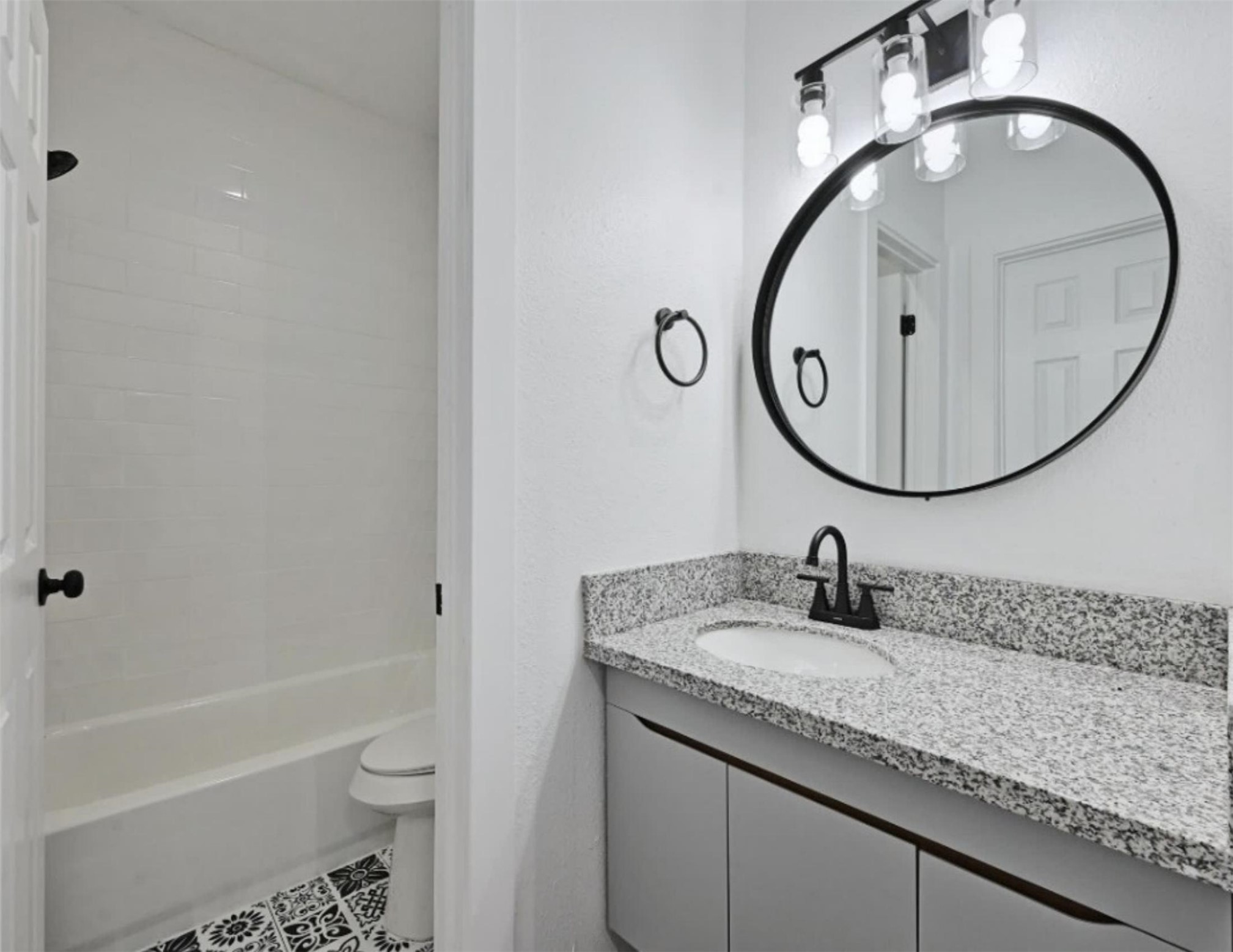 9508 Kempler Drive, Unit B Austin, TX 78748 - Photo 4 of 12 a bathroom with a granite countertop sink a toilet and a mirror