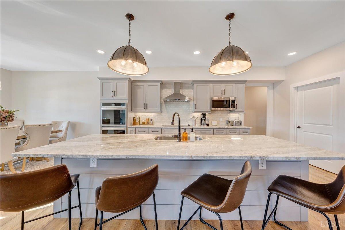 317 Bass Cove Road Huddleston, VA 24104 - Photo 16 of 90 a kitchen with stainless steel appliances a stove a sink and chairs