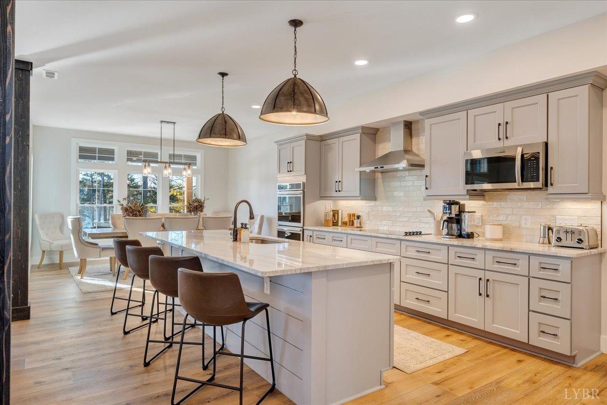 317 Bass Cove Road Huddleston, VA 24104 - Photo 17 of 90 a kitchen with stainless steel appliances a dining table chairs stove microwave and cabinets