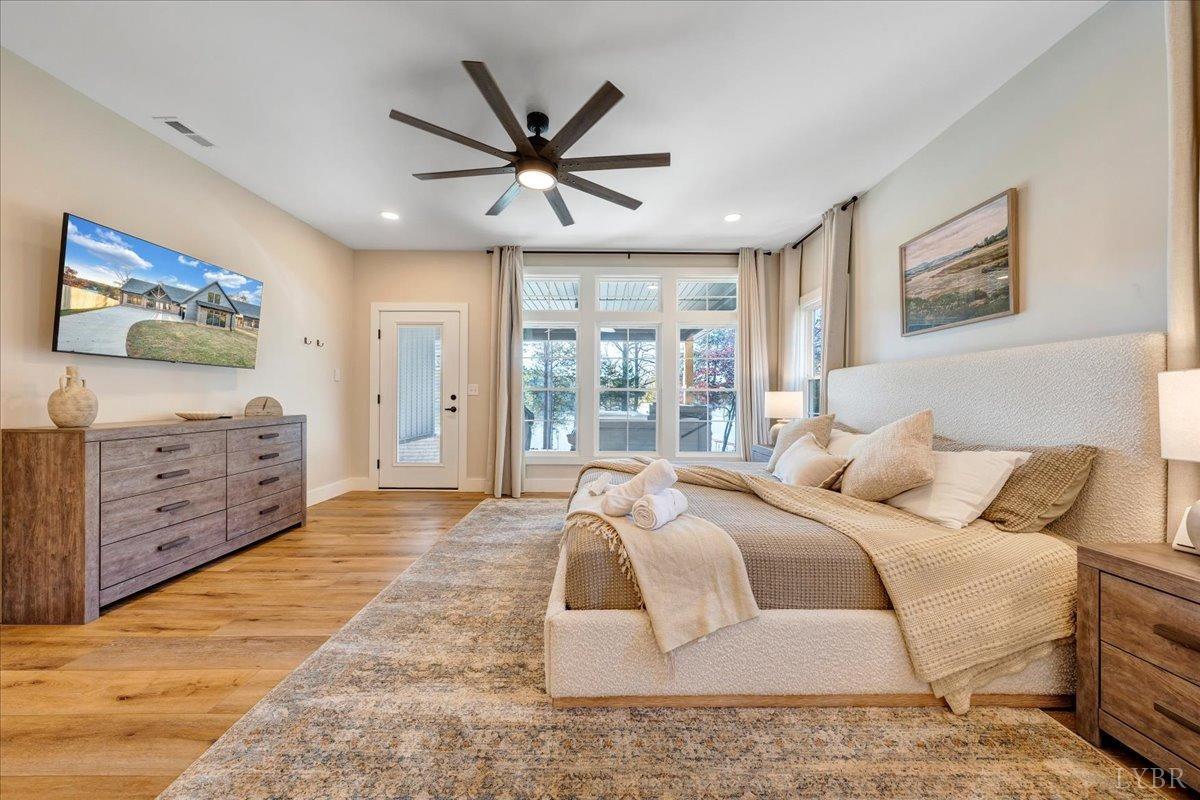 317 Bass Cove Road Huddleston, VA 24104 - Photo 23 of 90 a bedroom with a large bed and a chandelier